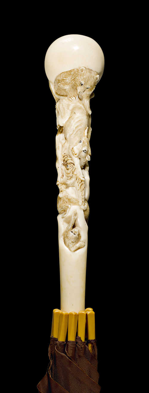 AN IVORY HANDLE CARVED WITH BEASTS.