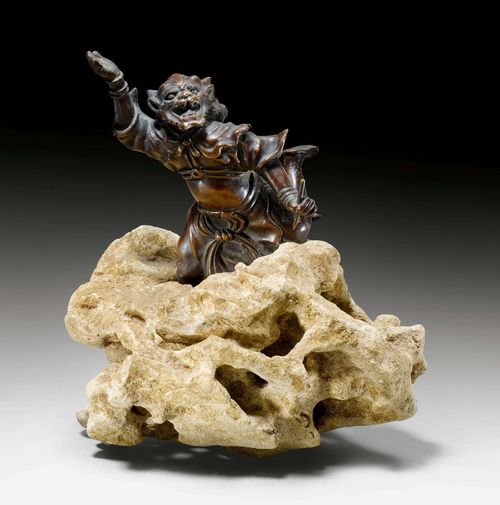 A BRONZE FIGURE OF AN ONI HOLDING A BRUSH. Japan, 19th c. height 18 cm (without stand). Added stone stand in the shape of clouds.