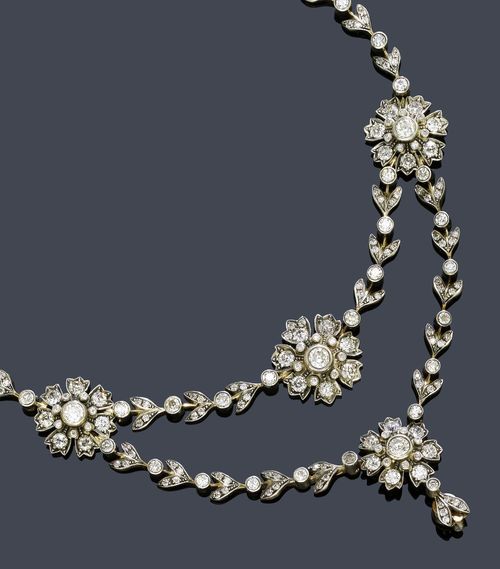 DIAMOND NECKLACE, KÖCHERT, Vienna, ca. 1890. Silver over pink gold. Fancy garland necklace with double-row front of 9 graduated flower motifs, each set with 15 old European-cut diamonds flanked by numerous diamond-set leaf motifs and 46 old European-cut diamonds. The lower part: 1 pendant with 1 old European-cut diamond and 1 leaf motif. Total diamond weight: ca. 20.00 ct. L ca. 43 cm. With case.