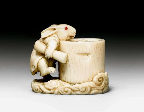AN IVORY NETSUKE OF THE MOON RABBIT PREPARING MOCHI CAKES. Japan, 19th c. Height 3 cm. One ear chipped.