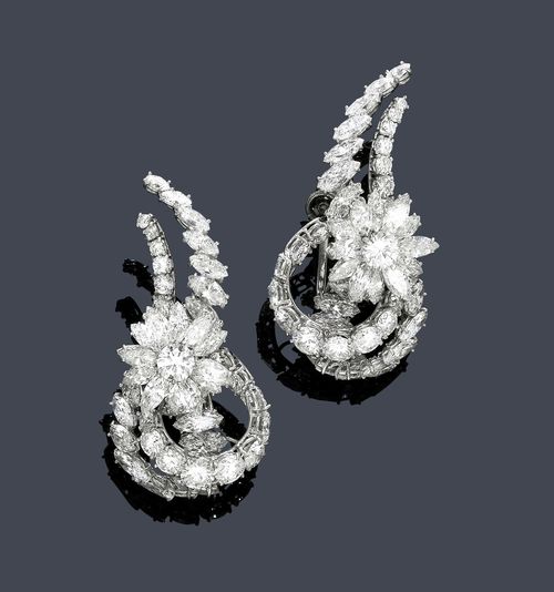 DIAMOND EAR STUDS, ca. 1950. Platinum, hinge white gold 585. Classic-elegant ear studs, each of one stylized flower and a double, curved band motif set throughout with 2 brilliant-cut diamonds weighing ca. 0.90 ct, 62 navette-cut diamonds weighing  ca. 6.00 ct and 38 brilliant-cut diamonds weighing  ca. 3.60 ct. Ca. 4.5 x 2.2 cm.