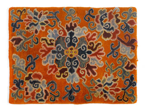 A SEATING CARPET WITH FLORAL DECORATION ON AN ORANGE GROUND.