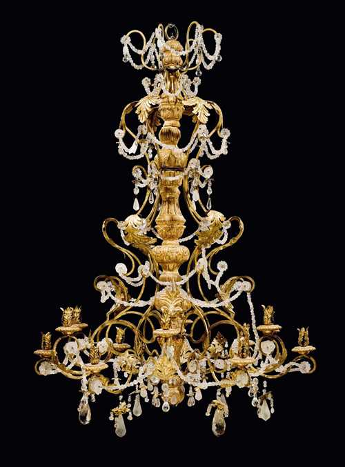 IMPORTANT CHANDELIER,Regence/Louis XV, probably Northern Italy or South France circa 1730/40. Carved oak, gilt iron and sheet metal, and glass and crystal hangings. With 12 light branches. H 140 cm. D 102 cm.