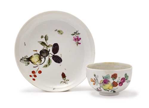A CUP AND SAUCER WITH FRUIT DECORATION