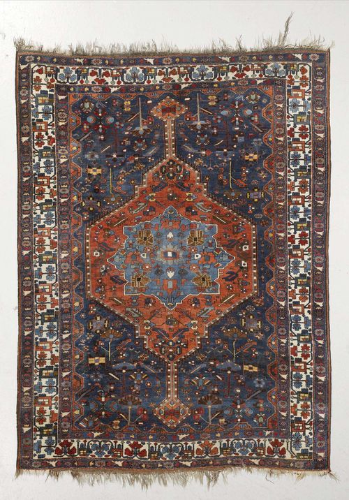 BIDJAR antique.Blue ground with medallions in red and light blue, patterned with stylized flowers, white border with trailing flowers, slight wear, 175x225 cm.