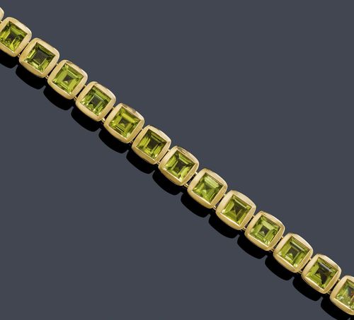 PERIDOT BRACELET WITH EAR STUDS . Yellow gold 750, 83g. Attractive bracelet of 17 square links with rounded corners, the sides matte-finished, each set with 1 square-cut peridot, total weight ca. 29.00 ct, L. ca. 19 cm. Matching Creole ear studs with a matte-finished surface, each set with 1 square-cut peridot, total weight ca. 3.50 ct. Ca. 2.2 cm.