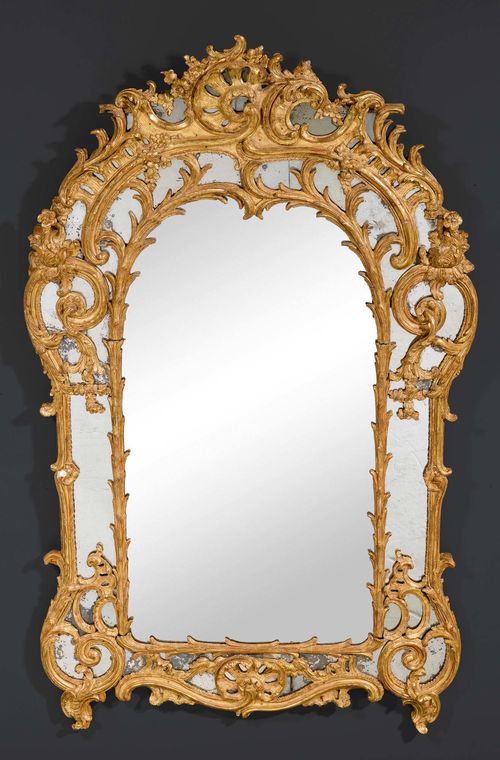 MIRROR "AUX CARTOUCHES",Louis XV, Paris circa 1760. Pierced, richly carved and gilt wood. H 170 cm. W 106 cm. Provenance: - Formerly M. Segoura, Paris. - Private collection, Switzerland.