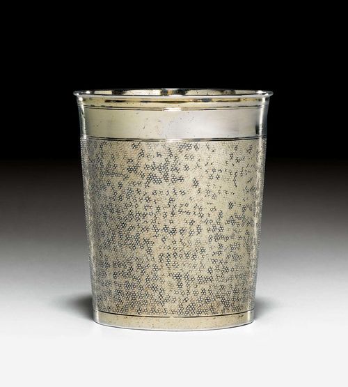 SILVER-GILT SNAKESKIN BEAKER,Augsburg 1690-95. Maker's mark Carl Schuch. Slightly conical form with a profiled edge. Walls embossed all around, smooth lip edge and foot. Flat bottom. H 7.8 cm, 120g. Provenance: German private collection.