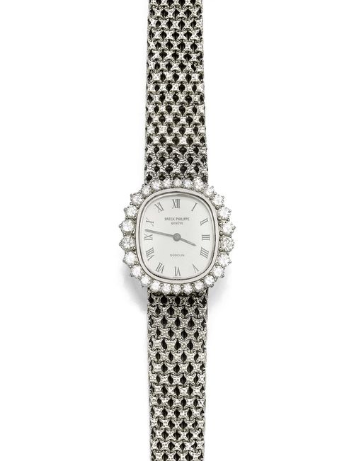 DIAMOND LADY'S WRISTWATCH, PATEK PHILIPPE FOR GÜBELIN, 1970s. White gold 750. Ref. 4137/1. Oval case No. 2707810 with brilliant-cut diamond lunette weighing ca. 1.30 ct. Silver-coloured dial with Roman numerals and black baton hands. Manual winding, movement No. 1261693, Cal. 16-250. Textured, original braided band in gold, L ca. 16 cm. Ca. 25 x 22 mm. With Patek leather pouch.