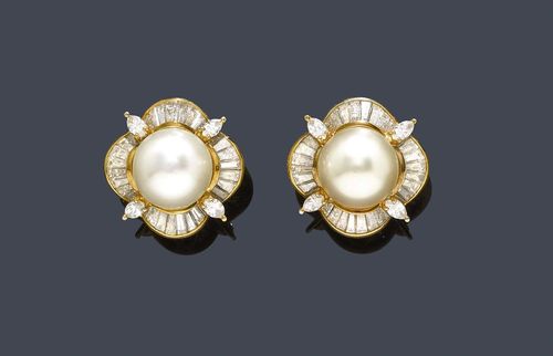 PEARL AND DIAMOND EAR CLIPS. Yellow gold 750. Classic-elegant ear clips with studs, each set with 1 slightly button-shaped South Sea cultured pearl of ca. 12.4 mm Ø within a border of 4 navette-cut diamonds and 28 baguette-cut diamonds weighing ca. 3.30 ct.