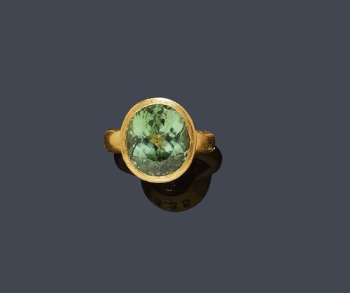 TOURMALINE AND GOLD RING. Fine gold. Casual attractive ring, the top set with 1 fine, oval mint-green tourmaline of 8.35 ct, in an inscribed collet setting. Size 51. With copy of insurance estimate, December 2009. Matches the previous lot.