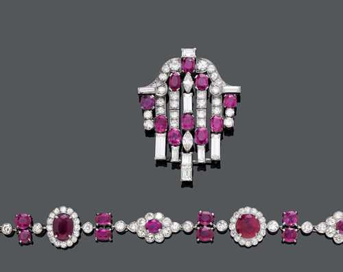 BURMA RUBY AND DIAMOND NECKLACE WITH PENDANT AND EAR PENDANTS, ca. 1900-1930. Silver, rhodium-plated. Very fancy necklace of 6 elliptic and 5 oval links, each set with 1 ruby within a border of diamonds, with 8 ruby pairs and 4 diamond pairs as intermediate links, and a group of 7 rubies in the centre. In total, 36 Burma rubies weighing ca. 40.00 ct, unheated, and 164 old European cut diamonds weighing ca. 20.00 ct. L ca. 48 cm. The lower part, a removable two-part pendant, can also be used as a clip brooch. The intermediate link set with 1 navette-cut diamond weighing ca. 1.00 ct, flanked by 2 rubies weighing ca. 1.40 ct. The geometrically designed clip brooch is set with 10 rubies weighing ca. 9.00 ct, 2 baguette-cut diamonds weighing ca. 2.00 ct, 8 smaller baguette-cut diamonds weighing ca. 3.60 ct, 2 navette-cut diamonds weighing ca. 1.00 ct, and 28 old European cut diamonds weighing ca. 2.60 ct. L ca. 7.5 cm. Matching ear pendants with 12 oval rubies and 16 baguette-cut rubies weighing ca. 5.50 ct, 26 baguette-cut diamonds and 38 diamonds weighing ca. 1.20 ct. L ca. 6 cm. With case and GGTL short report No. 14-B-2441.