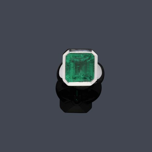 EMERALD AND DIAMOND RING, MAJO FRUITHOF. White gold 750. Casual-elegant ring, the top set with 1 fine, step-cut Columbian emerald weighing ca. 16.90 ct, in a collet setting. Size ca. 55. With case and insurance estimate by Fruithof, March 1999. Oral estimate by GGTL/Gemlab.