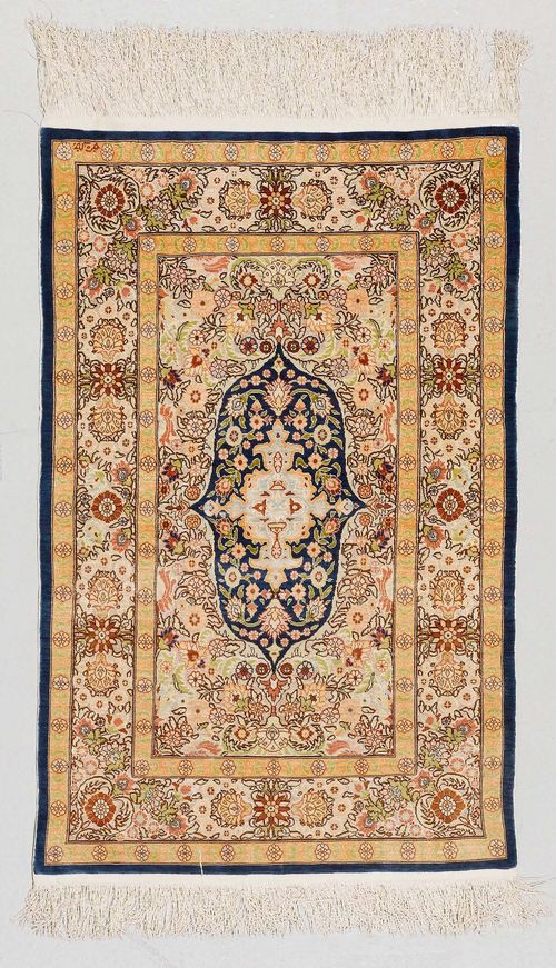 HEREKE SILK old.Colourful central field with a blue central medallion, the entire carpet is florally patterned, 70x110 cm.
