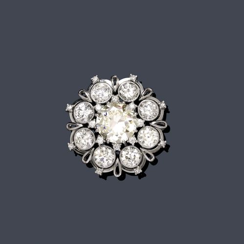 DIAMOND BROOCH / PENDANT, ca. 1950. White gold 750. Elegant brooch, the middle set with a diamond of 6.45 ct, N/ VS2*, within a border of 8 diamonds weighing ca. 6.50 ct. With Gemlab Report No. 2334/09, October 2009, * Potentially IF.