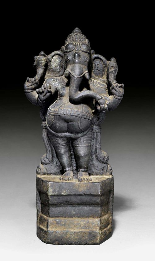 A BLACK STONE FIGURE OF THE STANDING GANESH. South India, circa 12th c. Height 37 cm.