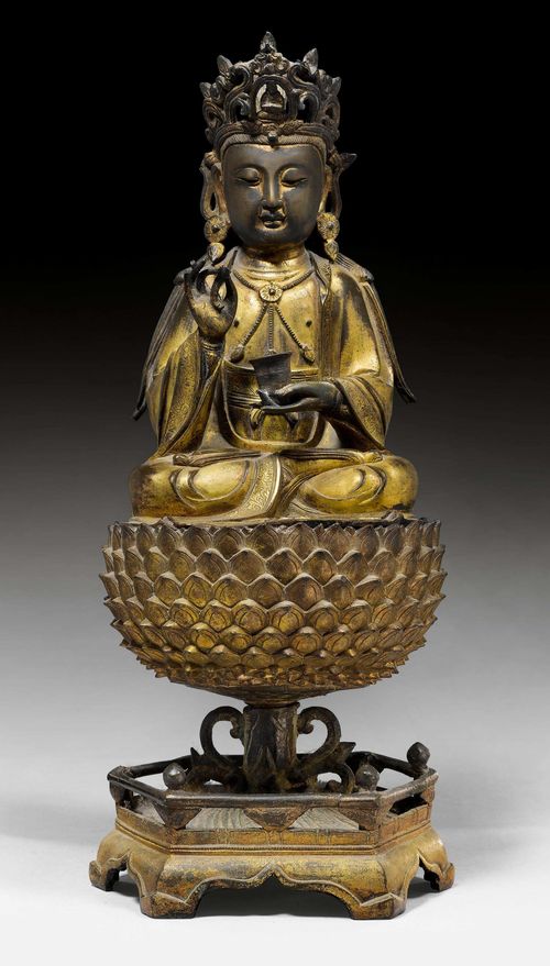 A GILT BRONZE FIGURE OF THE SEATED GUANYIN ON A LOTUS STAND. China, Ming dynasty, height 45 cm. Threepart. Remains of cold gilding.