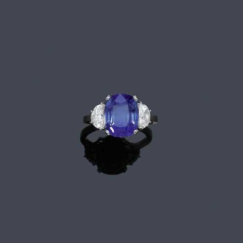 KASHMIR SAPPHIRE AND DIAMOND RING, ca. 1950. Platinum. Very attractive, elegant ring, the top set with 1 antique-oval, untreated Kashmir sapphire of 7.64 ct, flanked by 2 diamond half-moons weighing ca. 1.22 ct, ca. E/VS2. Size 56. With Gemlab Report No. 2678/10 of 20 July 2010 and SSEF Report No. 57726 of 27 October 2010.