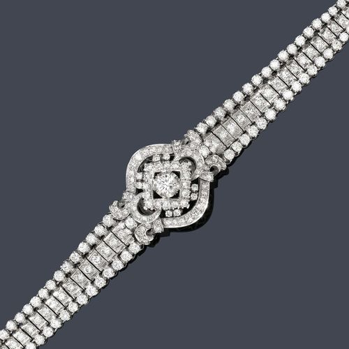 DIAMOND BRACELET, ca. 1950. White gold 750. Classic-elegant, three-row bracelet set throughout with numerous brilliant-cut diamonds, the centre additionally decorated with 1 florally open-worked ornament set with 1 brilliant-cut diamond of ca. 0.50 ct. In total: ca. 220 brilliant-cut diamonds weighing ca. 9.00 ct. L ca. 18 cm.