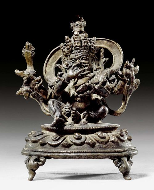 A BRONZE MINIATURE FIGURE OF THE FOUR ARMED MAHAKALA. Tibet, 16th c., height 8 cm. Minor damage at foot of throne.