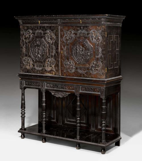 CABINET ON A STAND, Louis XIII, France ca. 1630. Ebony, exquisitely carved with scenes from the Iliad in a profiled frame, with flowers, leaves, decorative frieze, tortoiseshell, stained woods and ivory. Front with double-doors, 2 drawers on top and 3 other drawers. The inside with a central double-door surrounded by 14 drawers. Secret drawers. Gilt bronze mounts. 165x57x200 cm. Provenance: - from a European collection.