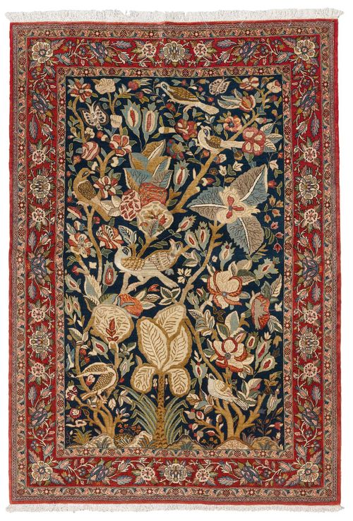 GHOM.Dark blue central medallion, opulently patterned with plants and birds, red border with trailing flowers, in good condition, 140x210 cm.