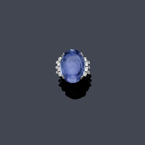 SAPPHIRE AND DIAMOND RING, ca. 1960. White gold 585. Classic-elegant ring, the top set with 1 light blue, oval Ceylon sapphire weighing ca. 60.00 ct, untreated, minimal signs of wear, flanked by 8 brilliant-cut diamonds and 6 baguette-cut diamonds weighing ca. 1.40 ct. Size ca. 53. With case. Oral estimate by GGTL/Gemlab.