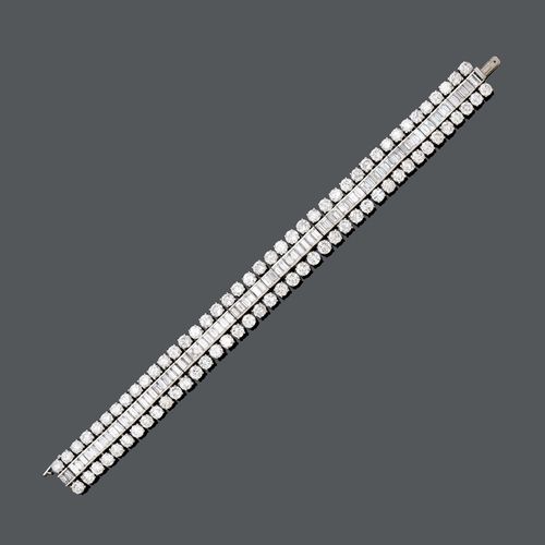 DIAMOND BRACELET, BY BOUCHERON, ca.  1960. Platinum 950. A 3 row bracelet, set with brilliant- and baguette-cut diamonds, totalling ca. 24.00 ct. Clasp white gold 750. L ca. 18 cm.