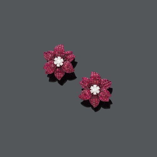 RUBY AND DIAMOND FLOWER EARCLIPS. White gold 750. Each set at the center with 7 brilliant-cut diamonds, weighing ca. 1.10 ct, the petals set with princess-cut rubies, invisible setting, totalling ca. 30.00 ct. Ca. 3 x 3 cm.