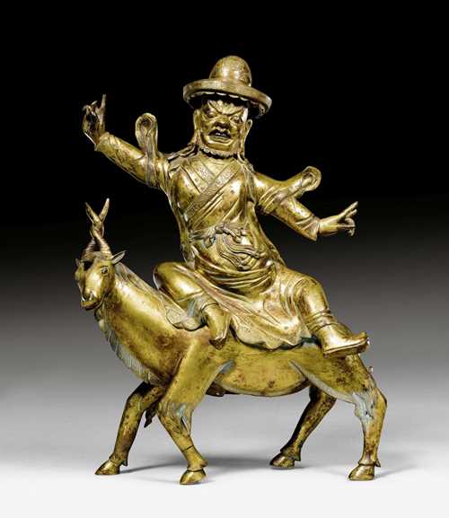 A POWERFUL GILT BRONZE FIGURE OF DAMCAN RIDING ON A BILLY GOAT. Tibeto-chinese, 18th c. Height 34 cm.