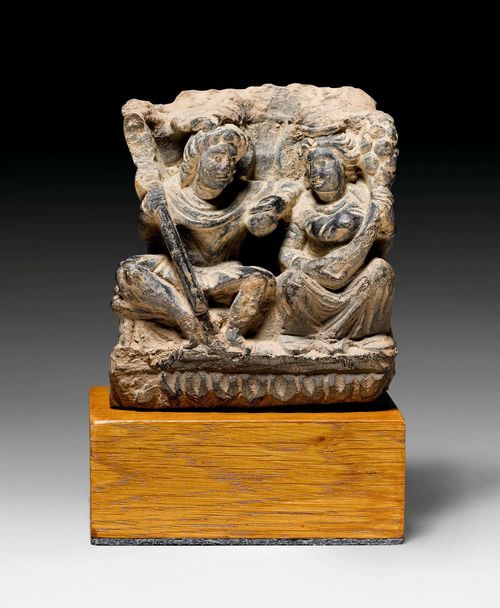 A GREY SCHIST RELIEF FRIEZE DEPICTING HARITI UND PANCHIKA. Gandhara, 2nd/3rd c. H 10 cm. Mounted on a wood stand. Minor repair.
