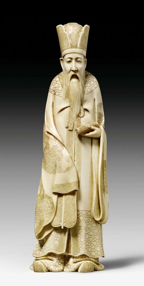 AN IVORY OKIMONO OF A STANDING SAGE WITH FAN AND SCROLL. Japan, Meiji period, height 21.5 cm. Signed.