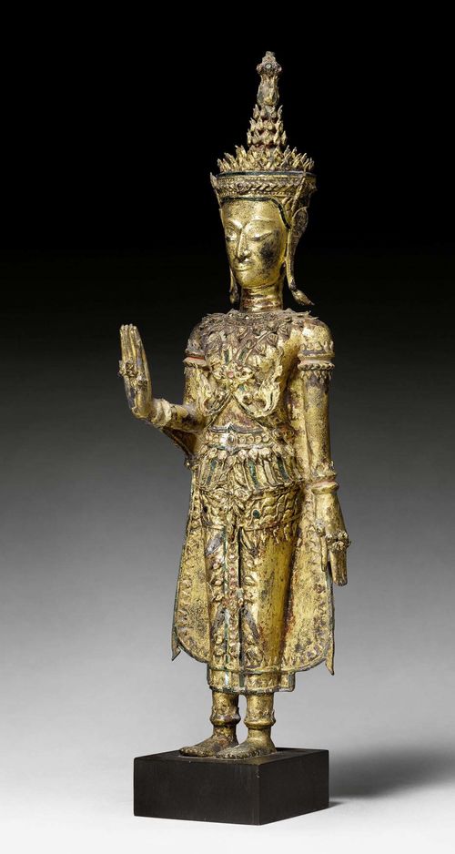 A STANDING GOLD LACQUERED BRONZE BUDDHA WITH RICH GLASS INLAYS. Thailand, 19th c. Height 50 cm. Minor damages.