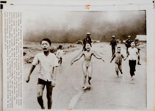 Ut, Nuynh "Nick" Cong (1951). "Terrified children fleeing a misplaced aerial napalm strike near Trang Bang, South Vietnam, on June 8, 1972". Original-Photographie. Getönter Silbergelatine-Abzug. Dat. blindgeprägter Stempel: "May 7 PM 1:33 1973". 17,2 x 22 cm. Mit einbelichteter Drucklegende. Rückseitig gestempelt.