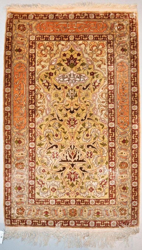 HEREKE silk.Yellow central field with white spandrels, finely decorated with trailing flowers and palmettes, beige border with inscriptions, good condition, 105x58 cm.