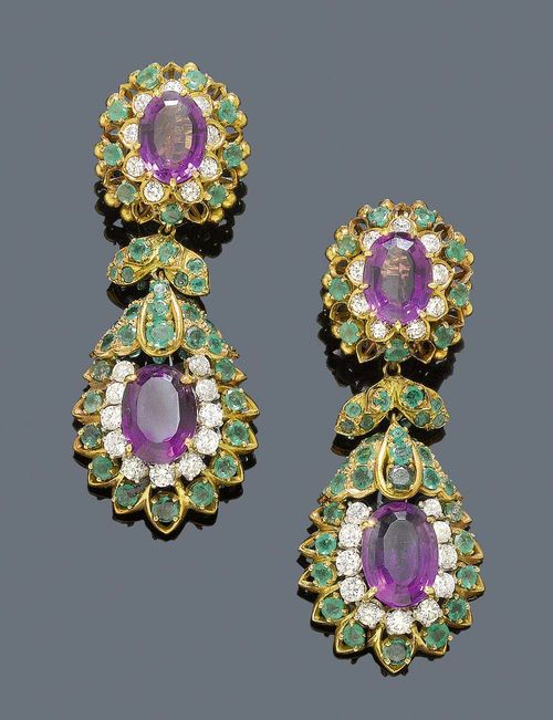 AMETHYST, EMERALD AND DIAMOND EAR PENDANTS, DAVID WEBB, ca. 1950. Yellow gold and platinum. Very fancy ear pendants, each with a florally open-worked clip part set with 1 oval amethyst and surrounded by 9 brilliant-cut diamonds and 9 emeralds.  The lower part with an emerald-set leaf motif and a flexibly mounted drop-shaped pendant, surrounded by brilliant-cut diamonds and emeralds. Total weight of the 4 amethysts ca. 15.00 ct, total weight of the 40 brilliant-cut diamonds set in platinum ca. 3.30 ct, total weight of the 90 emeralds ca. 4.50 ct. Signed David Webb.