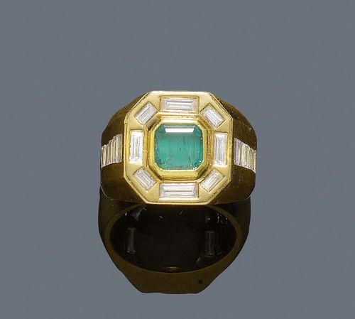 EMERALD AND DIAMOND RING. Yellow gold 750. Casual-elegant, solid Chevalière model, the top set with 1 step-cut emerald of ca. 1.00 ct, slight signs of wear, surrounded by 8 large baguette-cut diamonds of different sizes. The ring shoulders are additionally decorated with 10 baguette-cut diamonds. Total diamond weight ca. 2.00 ct. Size ca. 56.