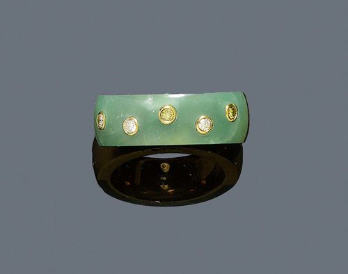 JADEITE AND DIAMOND RING. Yellow gold 750. Decorative band ring, the top set with 1 cut jadeite and additionally decorated with 5 brilliant-cut diamonds of different colours, diamonds weighing ca. 0.18 ct. Size 55.