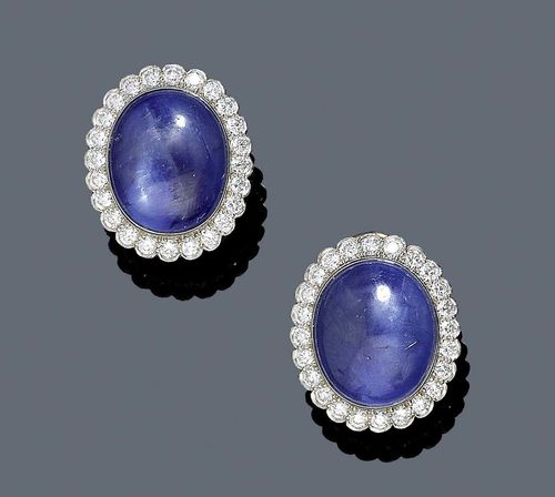 SAPPHIRE AND DIAMOND EAR CLIPS, ca. 1950. Platinum. Attractive ear clips, each with 1 oval sapphire cabochon weighing ca. 43.00 ct, in a classic surround of 24 brilliant-cut diamonds weighing ca. 0.70 ct. Clip part in yellow gold.