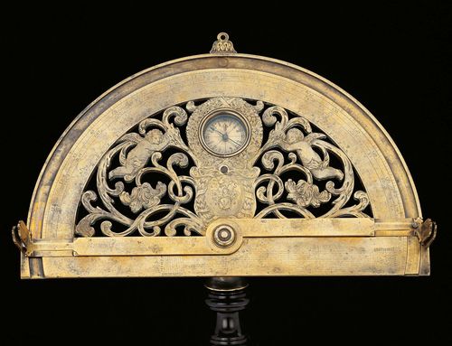 A BRASS GRAPHOMETER WITH FINE OPENWORK DECORATION, possibly France, 17th c. Bearing monogram MS. The protractor engraved with 2 grade scales 0-180. Small compass box with engraved directions and blued-steel needle. Base and alidades with upright sights (1 broken off), ball for ball-and-socket mounting, H 20 cm.