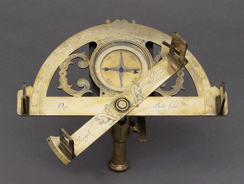 A BRASS GRAPHOMETER, circa 1750 sign. CLERGET PARIS AU BUTTERFIELD. The protractor engraved with 2 grade scales 0-180. Central compass box with wind rose, directions, blued-steel needle and graduated around the edge. Base and alidades with upright sights, ball for ball-and-socket mounting, H ca. 22 cm.