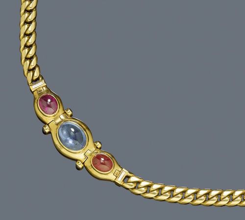 RUBY, SAPPHIRE AND DIAMOND NECKLACE, BULGARI, 1990s. Yellow gold 750, 63g. Casual-classic curb link chain necklace, the middle part set with 1 oval sapphire cabochon of ca. 8.15 ct, flanked by two ruby cabochons weighing ca. 6.13 ct and 4 small  sapphire cabochons weighing 0.66 ct and 2 baguette-cut diamonds weighing ca. 0.24 ct. Signed. L ca. 39 cm. With copy of insurance estimate, 1992.