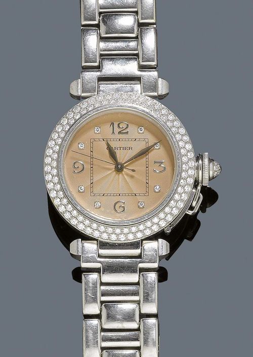 DIAMOND LADY'S WRISTWATCH, AUTOMATIC, CARTIER PASHA. White gold 750. Round case No. 2308 CC749691 with screw-down back and diamond-set screw-down crown, diamond lunette. Copper-coloured dial with appliqued gold numerals, diamond indices and gold hands. Automatic, movement No. 131822, signed, Cal. 049. Original gold band with fold-over clasp. D 35.5 mm.
