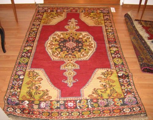 AVANUS old.Central medallion on a red ground with beige corner motifs, geometrically patterned with stylized plants, dark border, good condition, 200x120 cm.