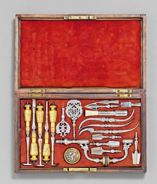 AN ELEGANT TREPANNING SET, France, possibly 19th c. Shaped and engraved, partly gilt steel. Consisting of a trepan with screw-handle showing Chronos, 7 drill bits, 3 elevators, 5 scrapers, etc. some instruments inscribed IOANNES GANTE. In walnut case with brass mounts lined with red suede (lid warped and cracked). 34.5x20.5x5.2 cm.
