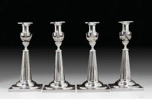 SERIES OF 4 CANDLESTICKS. Augsburg, 1793/95.Maker's mark Jeremias Balthasar Heckenauer. Fluted, conical shaft over a stepped round foot on a square plinth. Urn-shaped node and floral festoons. H 22 cm. 1200 g.