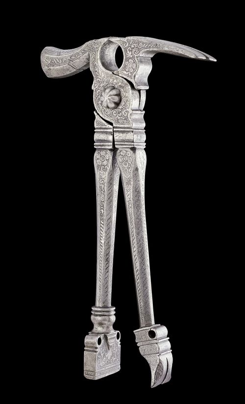 A RICHLY DECORATED COMBINATION TOOL, Nuremberg, circa 1580. Iron with fine etched decoration. The tool can be used as pliers, hammer, nail-puller or mini-anvil. L 21.5 cm.