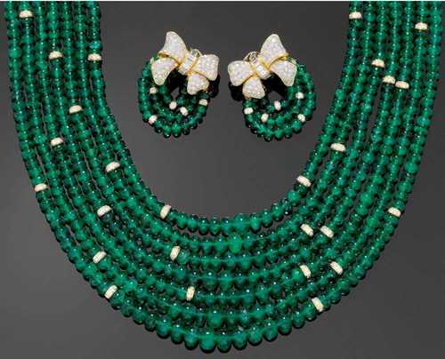 EMERALD AND DIAMOND NECKLACE WITH CLIP EARRINGS. Yellow gold 750. Stylish set, the seven-row necklace of numerous graduated fine emeralds of ca. 3.7 - 8.9 mm Ø, alternately decorated with brilliant-cut diamond rondelles as intermediary links. Large, bow-shaped fastener, completely set with ca. 190 brilliant-cut diamonds and 24 baguette-cut diamonds. Matching clip earrings, each of one diamond-set bow motif and 3 rows of emerald rondelles. Total emerald weight ca. 900 ct and total diamond weight ca. 17.70 ct. L ca. 59 cm.
