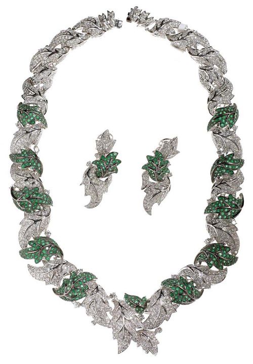 BRILLIANT-CUT DIAMOND AND EMERALD NECKLACE WITH CLIP EARRINGS. White gold 750. Very elegant, attractive set. The necklace of a row of slightly convex, naturally-shaped leaf motifs, set with 1554 brilliant-cut diamonds totalling ca. 32.70 ct. On the top: alternately arranged with 7 leaf motifs, set with 510 emeralds totalling ca. 14.60 ct. L ca. 45.50 cm, W 1.2-3.2 cm. Matching clip earrings with studs, each consisting of two leaf motifs set with a brilliant-cut diamond and one leaf motif set with 1 emerald. With a total of 178 brilliant-cut diamonds totalling ca. 4.06 ct and 80 emeralds totalling ca. 1.78 ct. L ca. 5 cm. With original case.