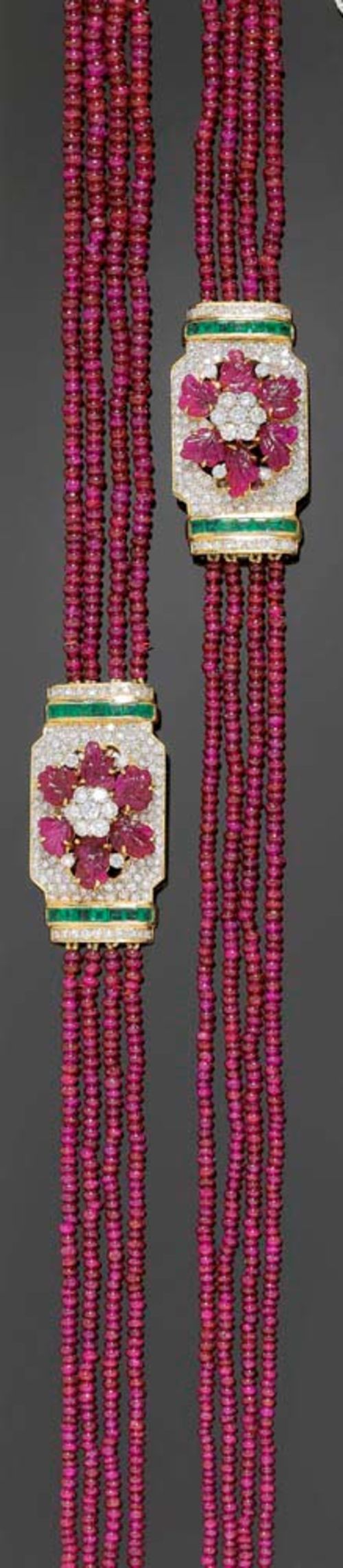 RUBY AND EMERALD SAUTOIR. Yellow and white gold 750. Elegant, 4-row sautoir of graduated ruby rondelles of ca. 2-5.3 mm, sautoir can be separated into 2 necklaces. Two very decorative fasteners, each adorned with a floral motif of 12 engraved ruby leaves totalling ca 13.50 ct and completely set with numerous brilliant-cut diamonds totalling ca. 5.35 ct and 28 carré-cut emeralds totalling ca. 2.60 ct. L ca. 93 cm, 50 and 43 cm respectively.